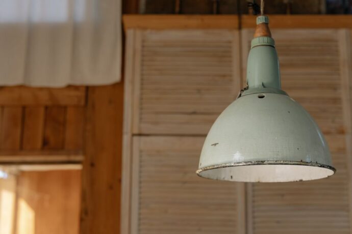 Plafonnier industriel en métal suspendu dans un salon moderne avec une décoration urbaine.